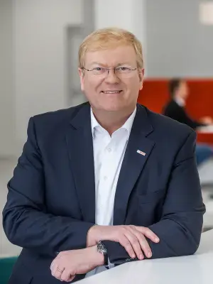 Stefan Hartung in a modern office, smiling and relaxed.